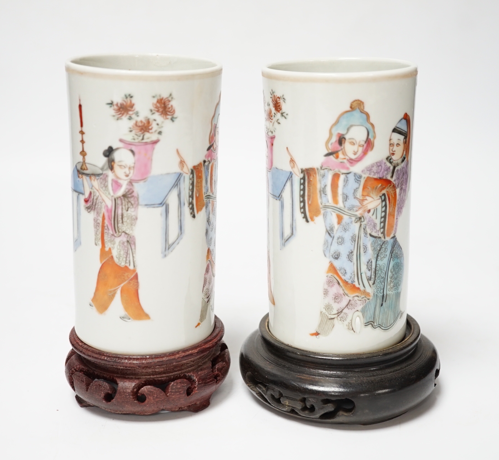 A pair of Chinese cylindrical famille rose brush pots on associated stands, largest 15cm high overall